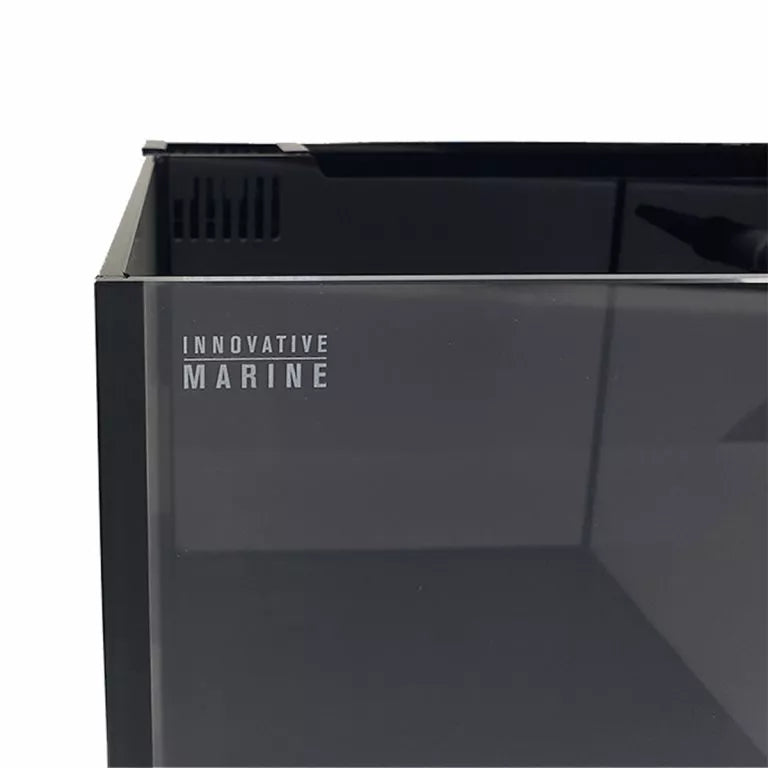 A close-up of the Innovative Marine - Fusion 20 Long aquarium tank corner showcases its sleek, rimless design and modern aesthetic. The empty black tank highlights sharp edges and a smooth surface, with the AIO Filtration System logo visible on the side, emphasizing quality.