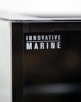 Close-up of a black corner on the sleek INT 112 Gallon Lagoon Aquarium Complete Reef System by Innovative Marine, with its name in white text, highlighting its modern design ideal for any Saltwater Reef System.