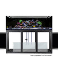 An Innovative Marine- EXT 200 Aquarium with APS Stand, showcasing colorful coral and vibrant marine life. The sleek stand has three open doors revealing glass compartments for equipment. Text below notes, Lower Plumbing and Sump Not Included.