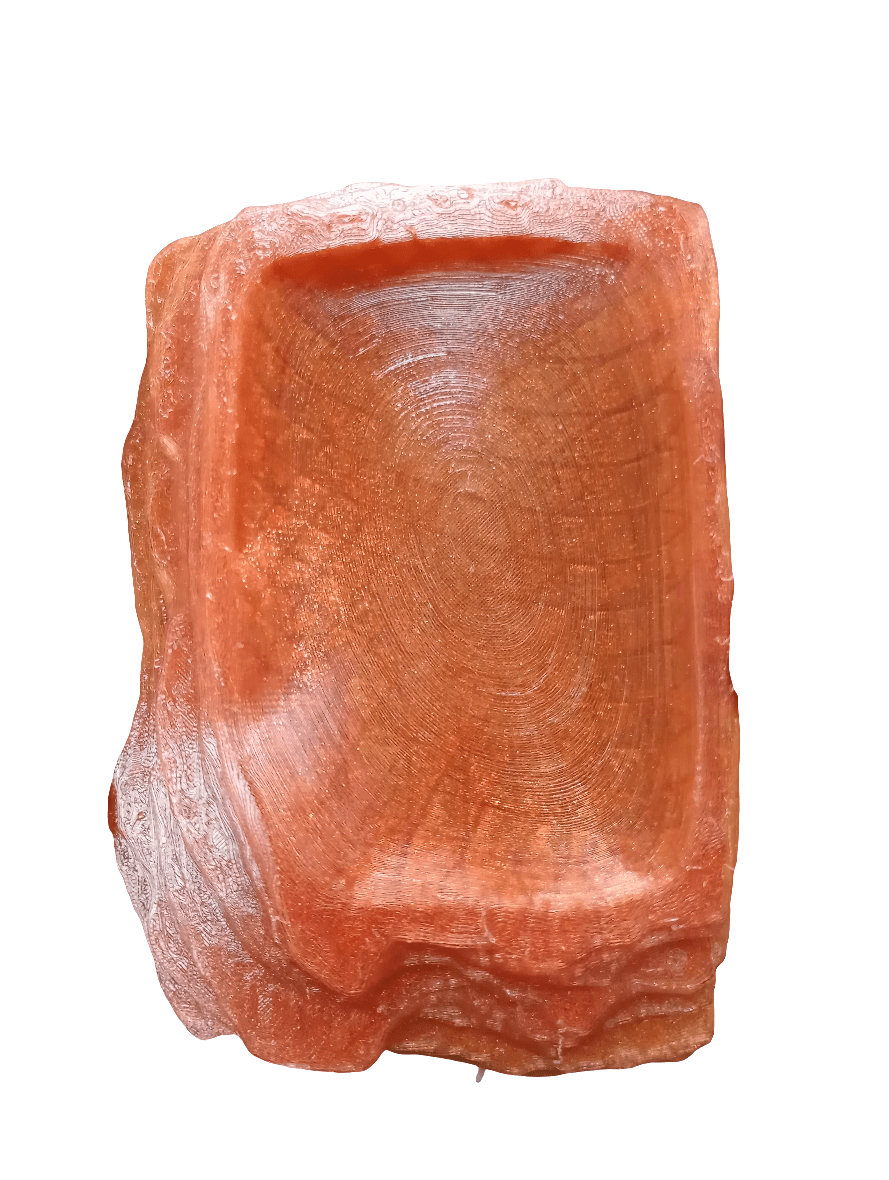 Introducing the AO Reptile Food Dish: a square, carved dish made from pink Himalayan salt. This exquisite piece showcases intricate natural patterns and boasts a slightly translucent appearance. The rough, uneven edges emphasize the raw, organic texture of the salt.