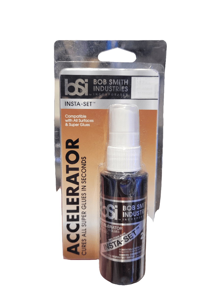 A 2oz Bob Smith Industries Insta-Set Super Glue Accelerator spray bottle, packaged in a clear plastic hanging display, is labeled to ensure compatibility with all surfaces and super glues while promising rapid curing in seconds.