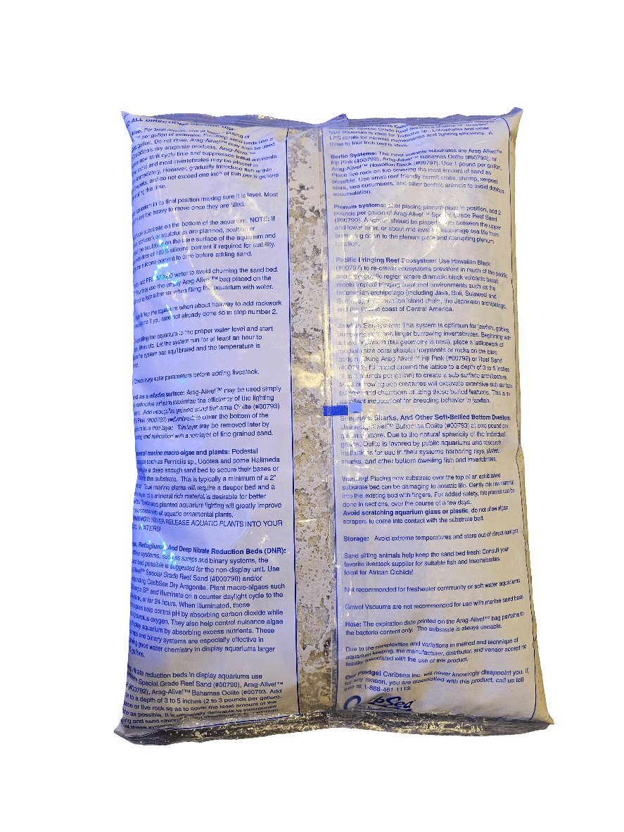 A sealed bag, predominantly white and blue, displays printed text prominently on the front. The filled bag shows noticeable creases and folds. The text provides instructions and details about the Caribsea - Arag Alive - Fiji Pink 20 lbs product inside.