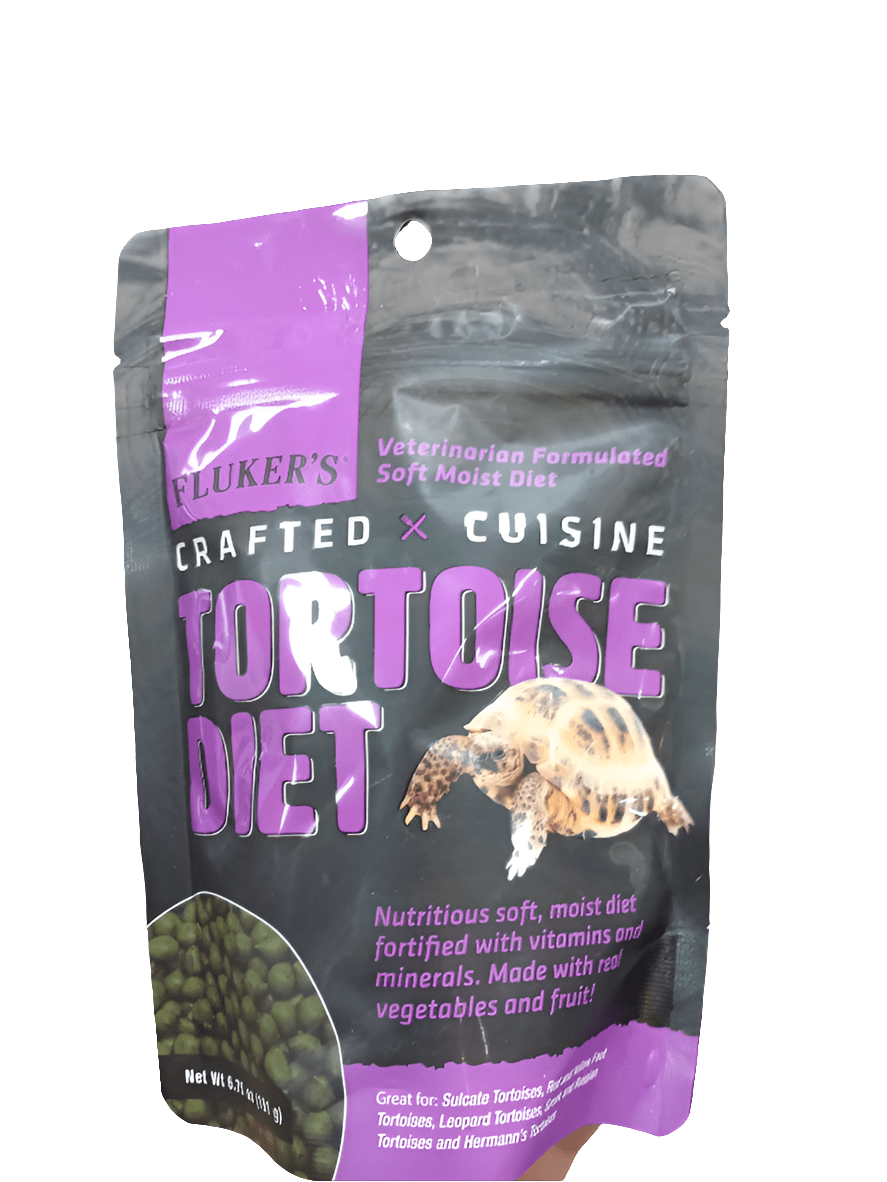 A 6.75oz package of Flukers Crafted Cuisine Tortoise Diet, with a purple and black design showcasing a tortoise photo, emphasizes its veterinarian-formulated composition as a soft, moist diet made from vegetables and fruit.