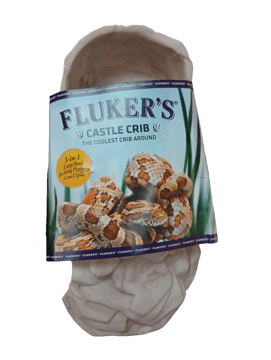 The packaging of the Flukers SML Castle Crib reptile habitat accessory displays an image of a snake on the label and describes it as a 3-in-1 large basking platform. This product is designed to resemble a natural-looking artificial cave.