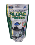 A package of Hikari - Algae Wafers - 8.8oz fish food. The packaging is green and white, showcasing images of fish along with the product name. It emphasizes that the wafers are perfect for bottom-feeding herbivores and include pure-cultured spirulina.