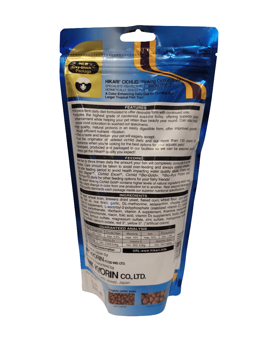 The image displays the reverse side of a 12oz. Hikari Cichlid Gold Medium Sinking fish food package, which is blue with a transparent section showcasing the pellets within. Text on the packaging highlights features, ingredients, and product information.