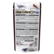 Back view of a Hikari - Crab Cuisine - Sinking - 1.76oz package shows product info, feeding instructions, ingredients, and company details in black text on white background, with illustrations of aquatic creatures.