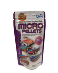 A 1.58 oz package of Hikari Micro Pellets fish food, with a purple and silver design showcasing tropical fish and emphasizing the enhanced color formula, is suitable for most tropical fish.