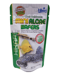 A package of Hikari - Mini Algae Wafers - .77oz designed for herbivorous fish. The green packaging showcases images of fish, emphasizes the nutrient content, and has a price tag of $5.99. The net weight is 0.77 oz (22g).