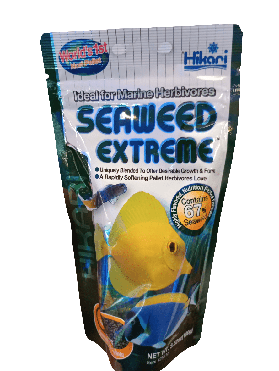 A 3.52oz package of Hikari Seaweed Extreme fish food for marine herbivores, adorned with an image of a yellow fish, boasts a 67% seaweed content and is designed to promote growth and form in fish.