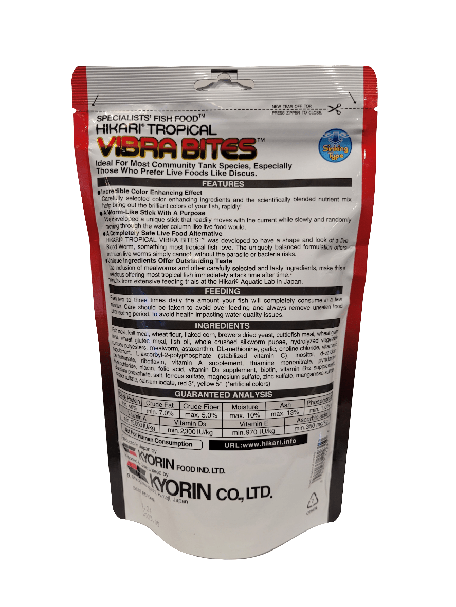 The image depicts the back of a Hikari Vibra Bites 1.23oz fish food package, which includes information on features, feeding instructions, ingredients, guaranteed analysis, and company details in English. The packaging color scheme includes predominantly red, white, and black tones.