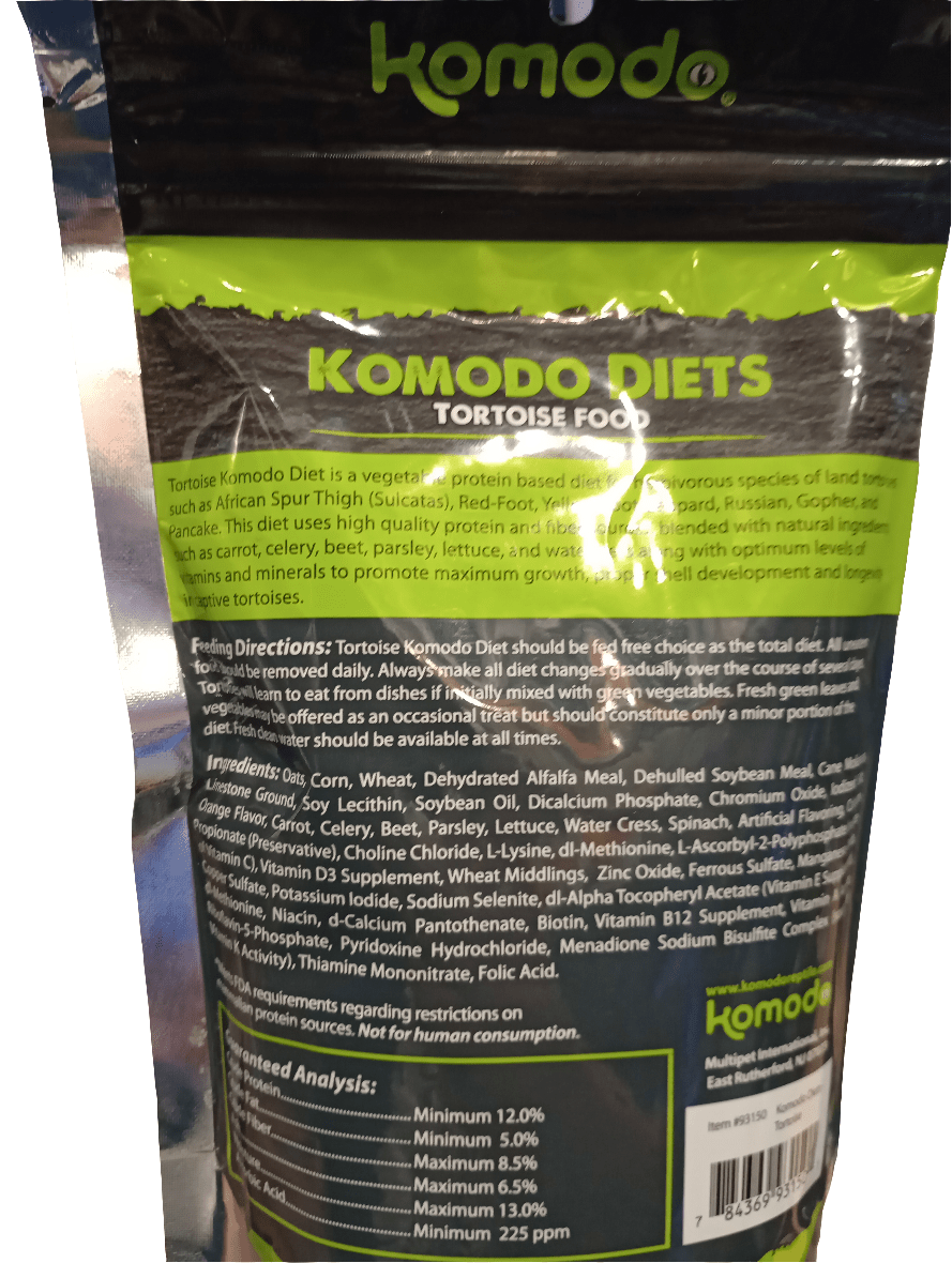 An image of the Komodo Diets Tortoise Food 14oz package. The front label showcases a green and black design that includes information on feeding directions, guaranteed analysis, and ingredients, with the brand name Komodo prominently displayed at the top.