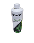 A 500ml bottle of Seachem - Flourish, designed as a comprehensive supplement for planted aquariums, featuring a white label adorned with green plant imagery and nutrient information, and topped with a white cap.