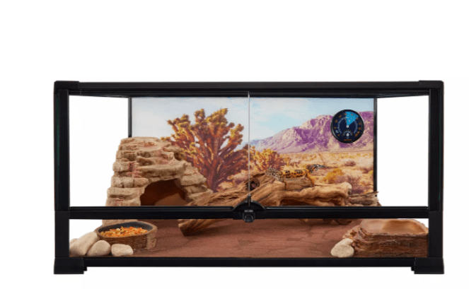 Introducing the Thrive 20 gallon desert front opening terrarium, designed to mimic a desert landscape complete with a rocky cave, food dish, water bowl, and wooden branches. The backdrop beautifully displays mountains and desert plants, and a thermometer is conveniently attached to the side.