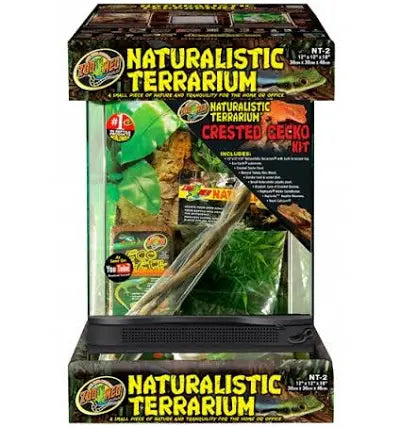 Image of a Zoo Med - Crested Gecko Kit. The packaging showcases plants, branches, and the brands logo in a green and black color scheme with Includes and Crested Gecko Kit text highlighted.