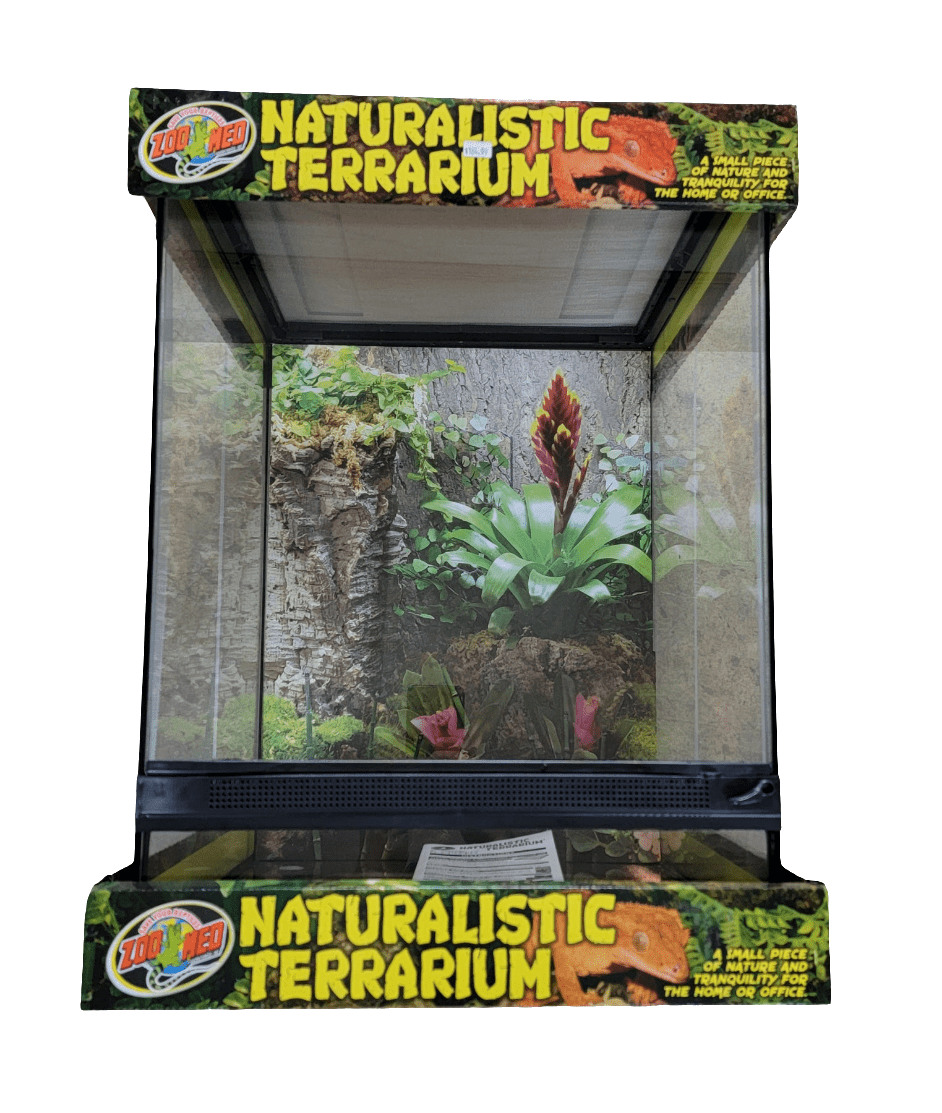 The Zoo Med Naturalistic Terrarium 18x18x24 boasts clear glass sides and showcases a lush interior arrangement, complete with a large central plant displaying vibrant pink and green leaves, all surrounded by moss and bark. The packaging is colorful and adorned with jungle-themed graphics.