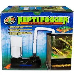 The ReptiFogger Terrarium Humidifier box showcases an image of the setup, featuring a fogging unit with a hose attached to a glass terrarium containing plants and a chameleon.