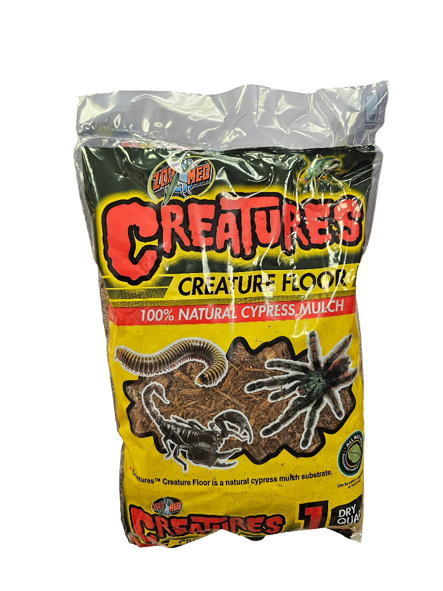 A package of ZooMed - Creature Floor 1 Quart is displayed, labeled 100% Natural Cypress Mulch, with images of a centipede, tarantula, and scorpion on a yellow background with bold red and black text.