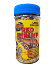 A transparent jar with a blue lid holds sun-dried red shrimp, labeled ZooMed Red Shrimp .5oz, indicating high protein content appropriate for large aquatic turtles.