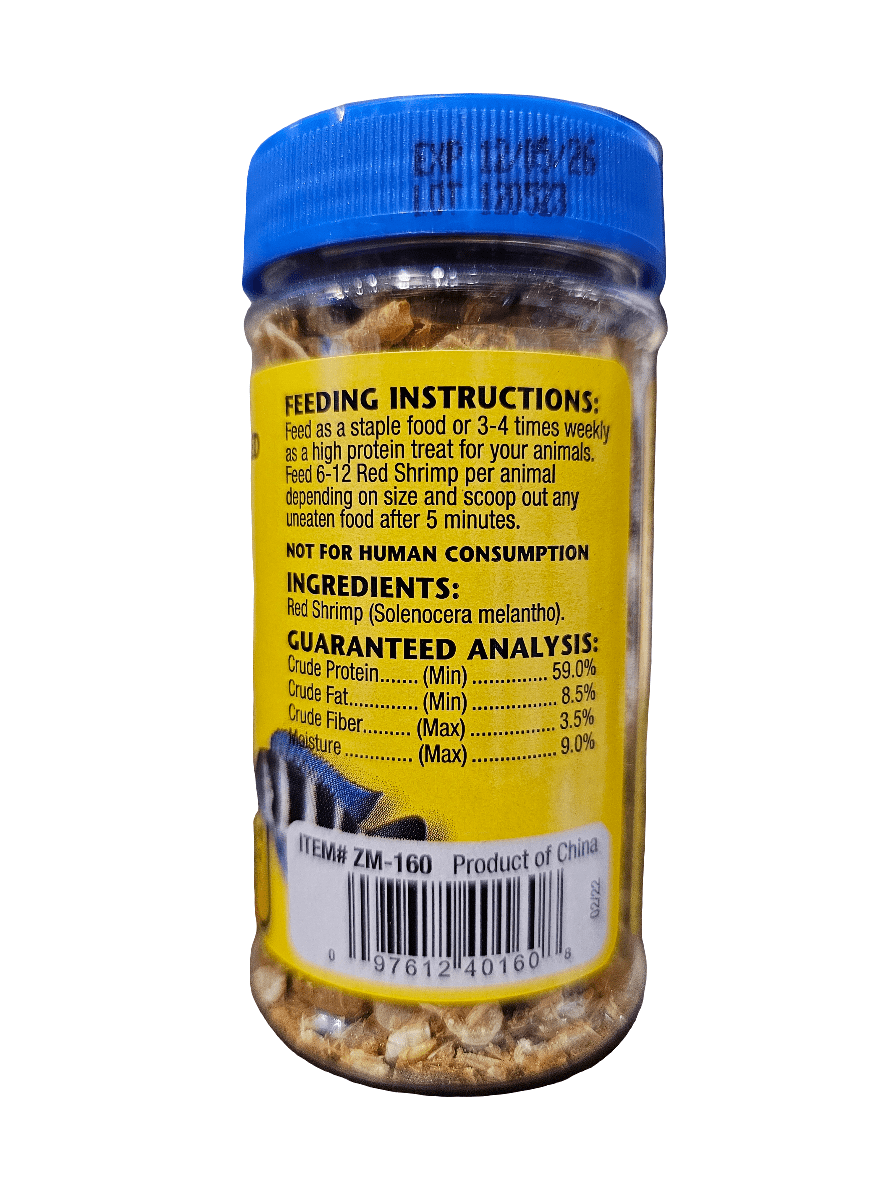 A jar of ZooMed Red Shrimp .5oz featuring a blue lid. The label provides feeding instructions, lists ingredients (Red Shrimp/Solenocera melantho), and includes a guaranteed analysis of crude protein and fat content. Barcode and product information are visible at the bottom.