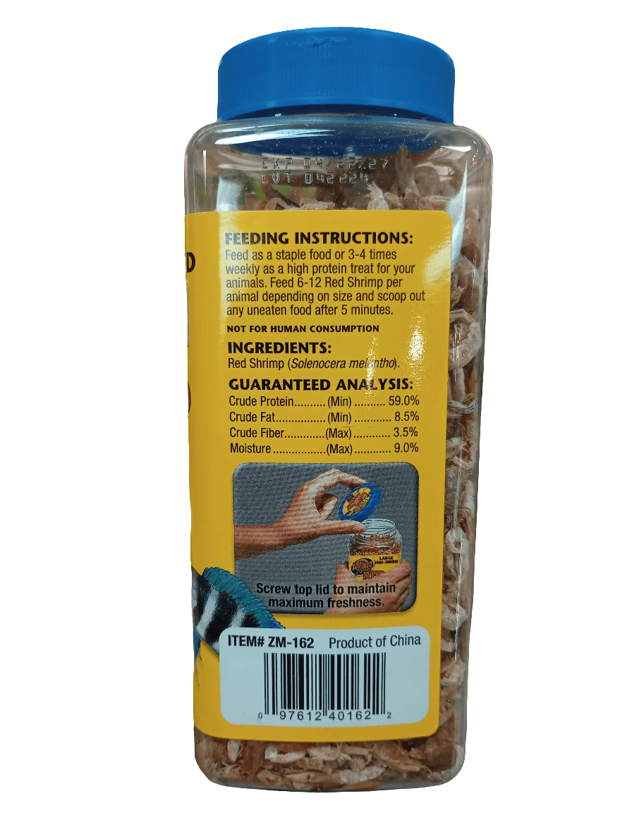 The ZooMed - Red Shrimp 5oz is a transparent plastic container of protein-rich fish food featuring sun-dried red shrimp. It has a yellow label detailing feeding instructions, guaranteed analysis, and a warning stating it is not for human consumption. This product is suitable for aquatic turtles and is made in China.