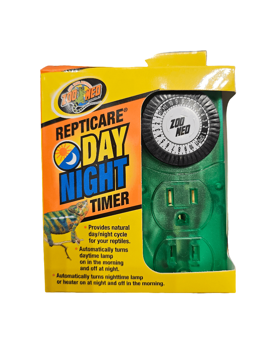 A ZooMed - Repticare- Day/Night Timer is in its packaging. The box is yellow with a vibrant logo, highlighting its purpose for reptile lighting and managing day/night cycles. It includes automatic lamp control with a circular analog timer and electrical outlets set on a green base.