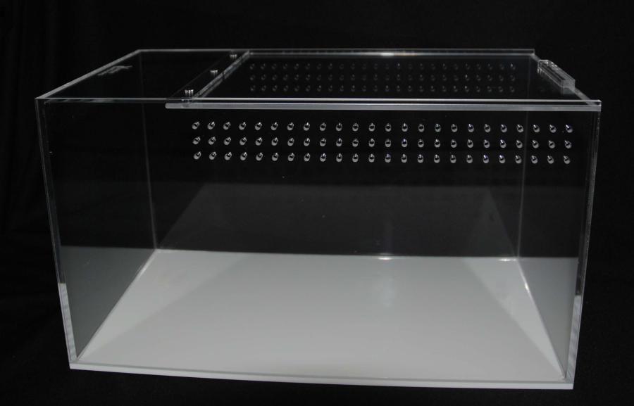 A large Vivarium Electronics acrylic enclosure, transparent and rectangular with a lid and perforated side, elegantly stands against a black background, highlighting its depth and dimensions.