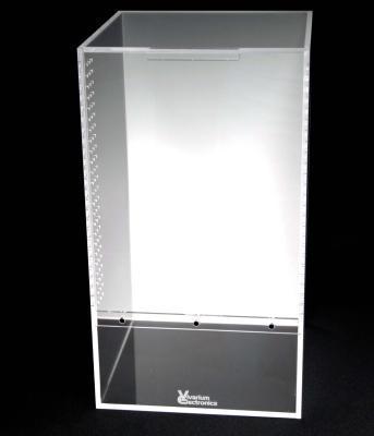 The Vivarium Electronics Acrylic Enclosure-Large is a transparent rectangular acrylic enclosure with a top opening and perforated sides. The solid bottom displays the Vivarium Electronics logo, making it ideal for laboratory or scientific use against a dark background.